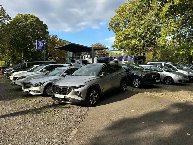 Gebrauchtwagen verschiedener Marken auf dem Hof von EYC Global an der Frankfurter Straße 645 in Köln-Ostheim, dahinter das Verkaufsgebäude